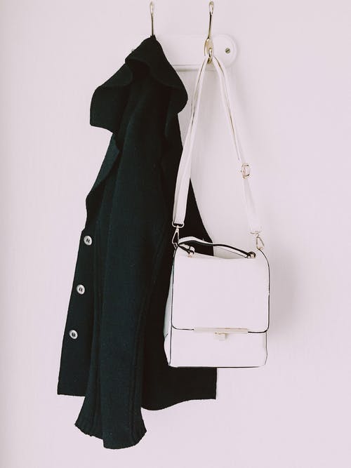 白色皮革斜挎包和黑色派克大衣 · 免费素材图片