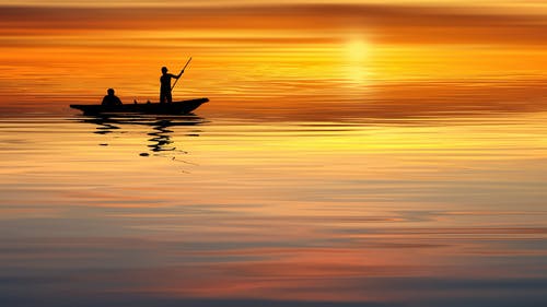 剪影船和男子在海洋上航行 · 免费素材图片