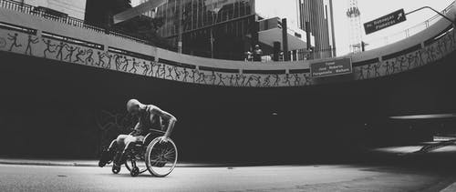 人坐在轮椅上的灰度照片 · 免费素材图片