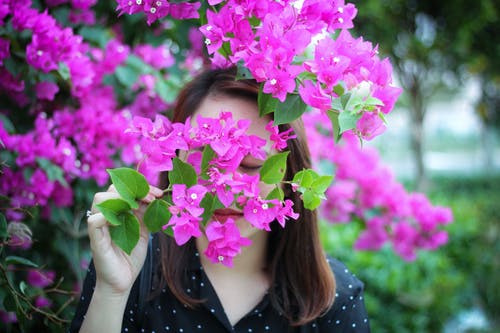 女人闻紫色花朵的照片 · 免费素材图片