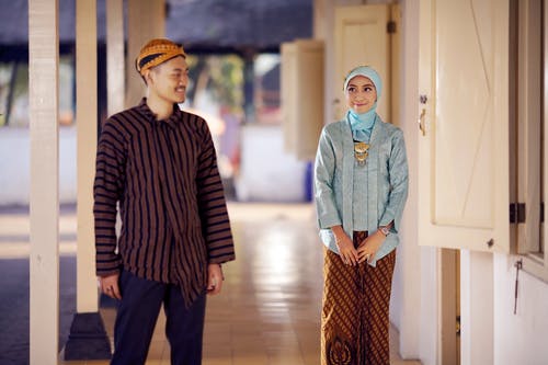 男人瞥了一眼站在窗户旁边的女人 · 免费素材图片