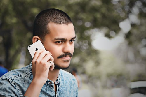 男子手持金iphone 6的选择性聚焦摄影 · 免费素材图片