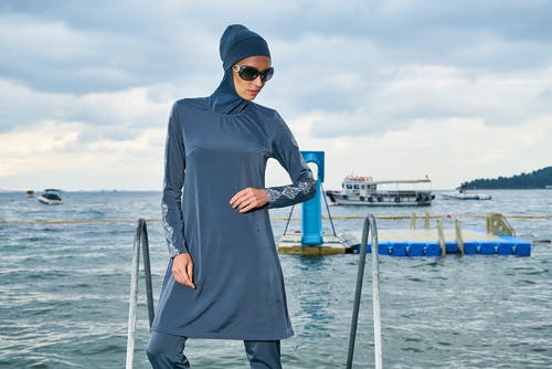 蓝色头巾和长袖的裙子站在水体附近的女人 · 免费素材图片