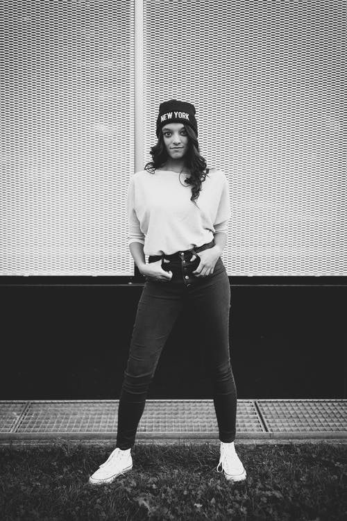 女人站在大楼前的灰度摄影 · 免费素材图片