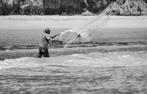 人钓鱼的灰度照片 · 免费素材图片