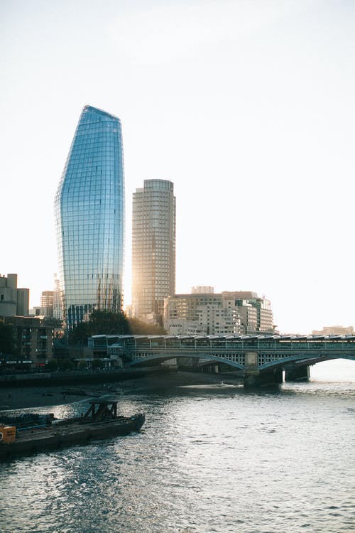 桥和水体附近的灰色混凝土建筑物 · 免费素材图片