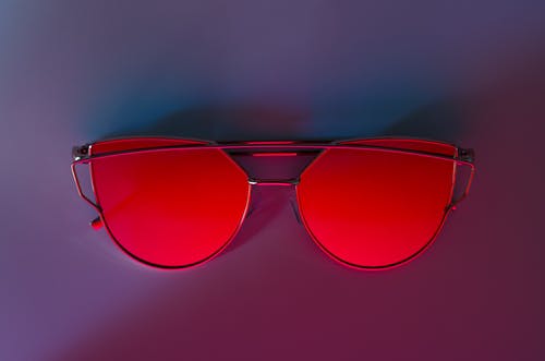 粉红色的表面上的红色太阳镜 · 免费素材图片