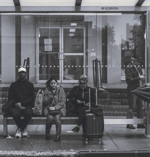 人们在公交车站的长椅上坐着 · 免费素材图片