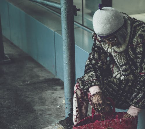 戴着白帽子坐在壁架上的女人 · 免费素材图片