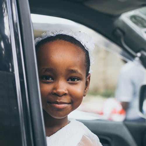 小女孩微笑着穿着白色上衣车内 · 免费素材图片