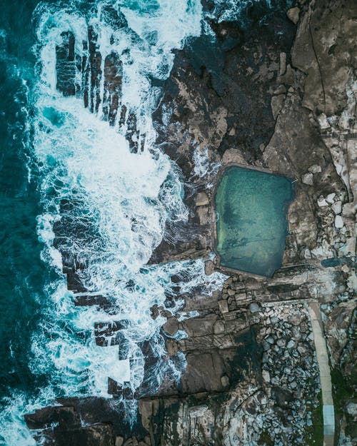 海洋和岩层航拍旁边的天然游泳池 · 免费素材图片