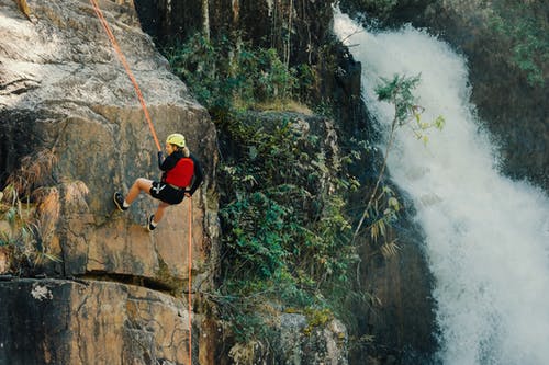 女人摇摆瀑布附近的攀岩 · 免费素材图片