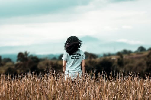 女人站在麦田上的选择性焦点摄影 · 免费素材图片