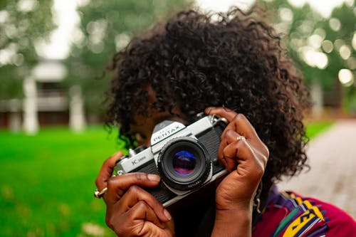 拿着照相机的妇女的选择聚焦摄影 · 免费素材图片