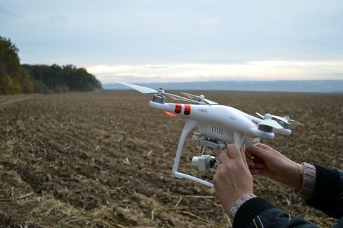 在开放领域持有dji Phantom 3 Quadcopter无人机的人 · 免费素材图片