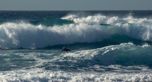 在海洋上冲浪的人 · 免费素材图片