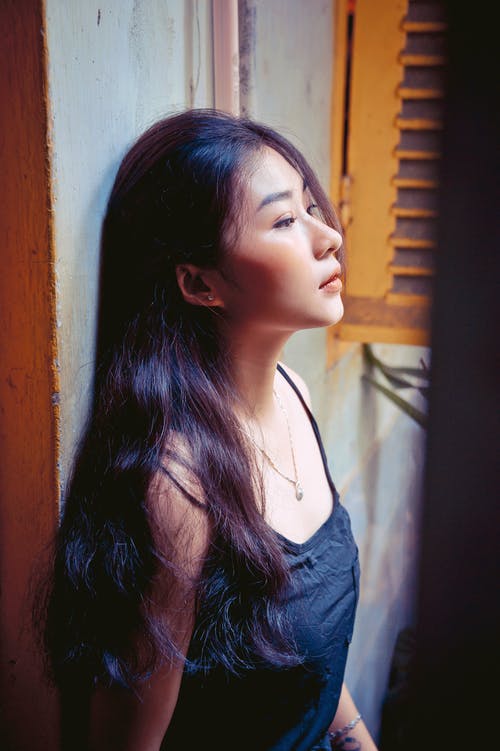 靠在墙上的女人的照片 · 免费素材图片