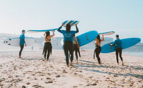 一群人携带冲浪板 · 免费素材图片