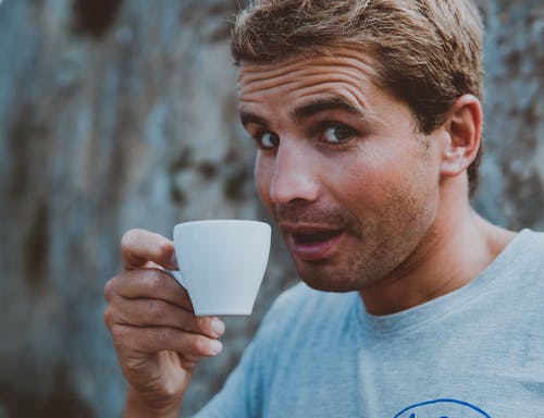 男子手持茶杯的选择性聚焦摄影 · 免费素材图片