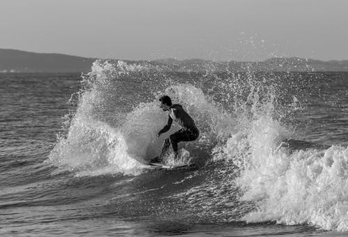 男子冲浪的灰度照片 · 免费素材图片