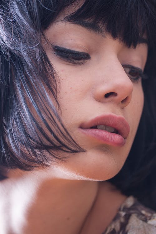 女人穿着黑色睫毛膏和眼线po着嘴唇 · 免费素材图片