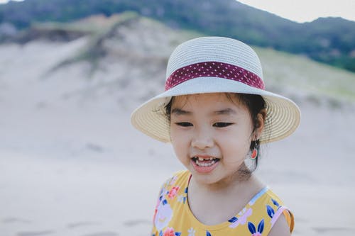 戴白帽子微笑的女孩 · 免费素材图片