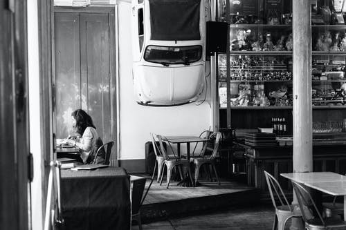 女人坐的灰度照片 · 免费素材图片