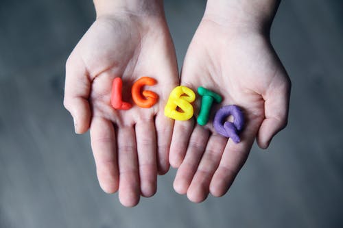 Lgbtq字母在一个人的手上的特写照片 · 免费素材图片