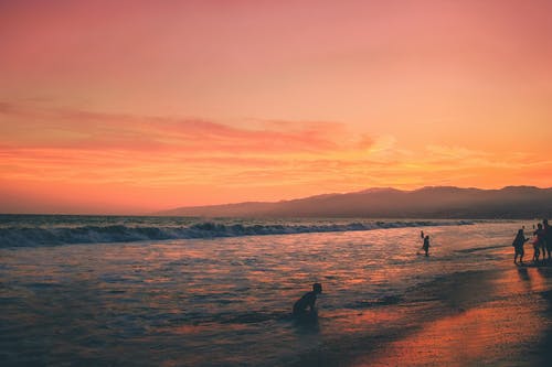 日落期间人们在海边的照片 · 免费素材图片