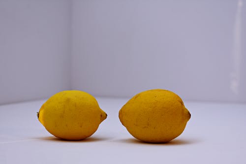白色表面上的两个黄色柠檬 · 免费素材图片