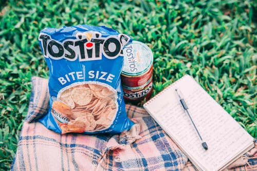 罐头和笔记本旁边的tostito包 · 免费素材图片