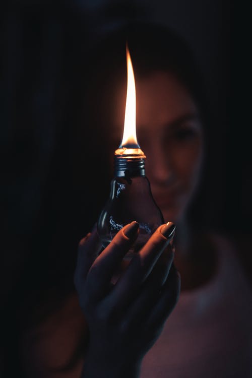 女人抱着点燃的油灯 · 免费素材图片