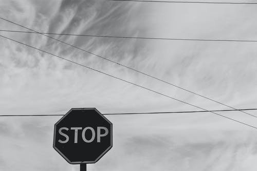 天空下停车标牌的灰度摄影 · 免费素材图片