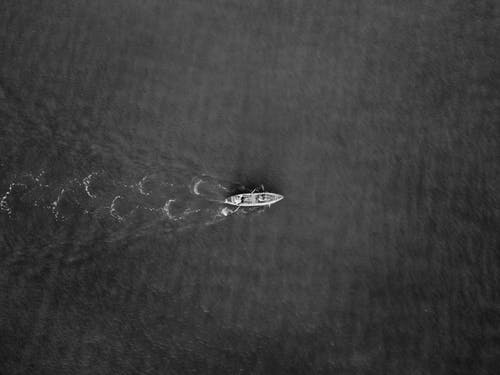小船在水面上的灰度照片 · 免费素材图片