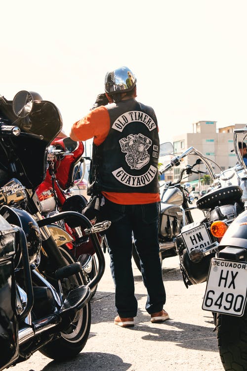 男子站在摩托车包围 · 免费素材图片