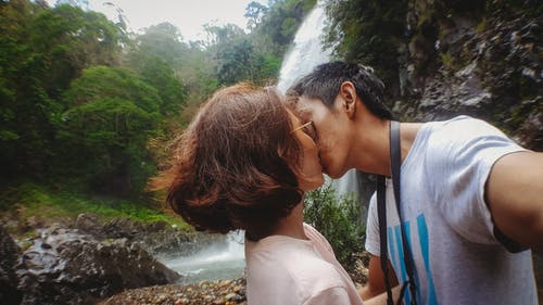 瀑布背后的男人亲吻女人 · 免费素材图片