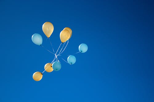 黄色和蓝色的气球，在天空上的照片 · 免费素材图片