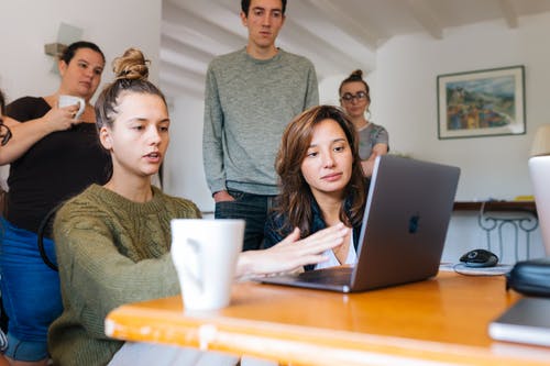 女人在一群人使用macbook的绿色上衣 · 免费素材图片