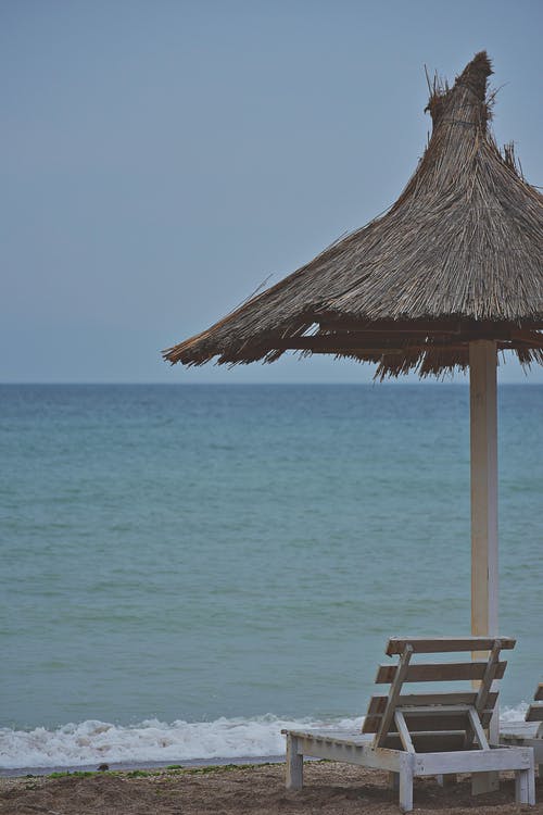 海滨躺椅旁边的露台伞 · 免费素材图片