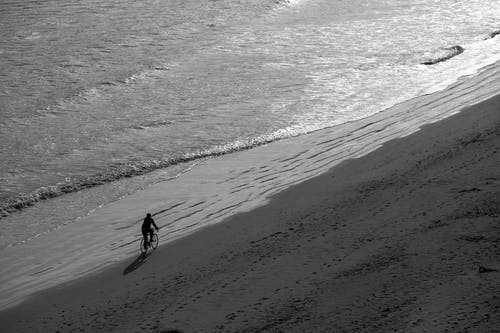 男子在海边骑自行车 · 免费素材图片