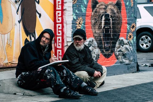 两名男子坐在人行道上 · 免费素材图片