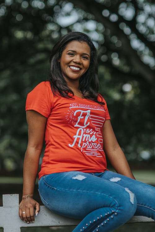 女人坐在栅栏上的照片 · 免费素材图片