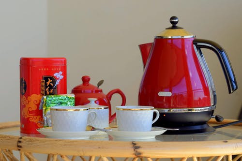 白色茶杯旁边的红水壶 · 免费素材图片