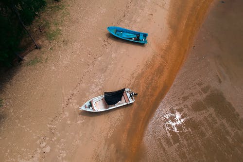 两只蓝色和白色的小船在岸上 · 免费素材图片
