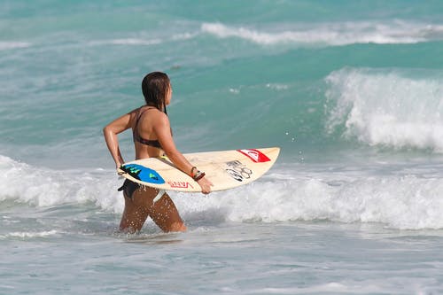 女人携带冲浪板 · 免费素材图片
