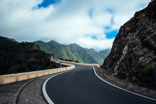 悬崖山附近的黑沥青路 · 免费素材图片