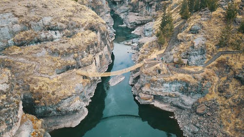 连接两个悬崖的棕色吊桥的航拍 · 免费素材图片