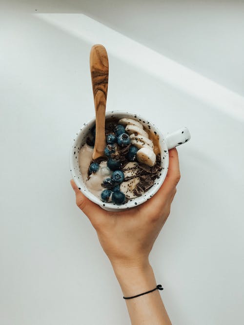 拿着白色陶瓷杯的人 · 免费素材图片