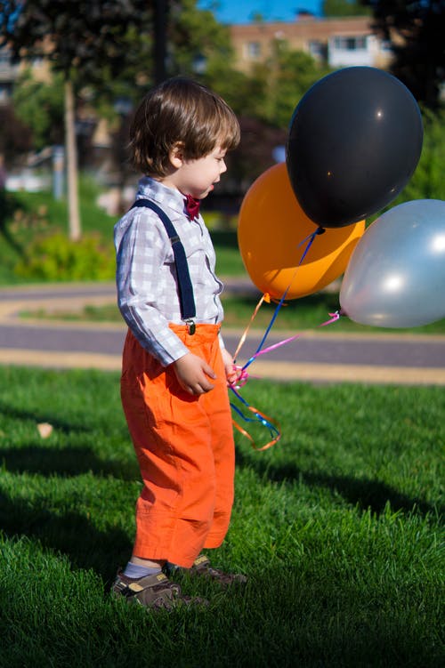 男孩抱着三个气球 · 免费素材图片