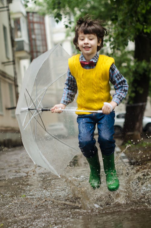 男孩微笑着跑着伞 · 免费素材图片